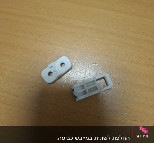 חלקי חילוף מפלסטיק לבן למוצרי חשמל על משטח עץ